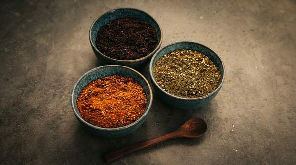 Editorial illustration for Sumac vs. Za'atar: One Is a Berry, One Is a Blend — Here's How to Tell Them Apart