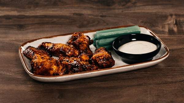 Editorial illustration for Two Inventors, One Wing: The Contested History of Buffalo Wings